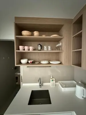a kitchen with a sink and shelves with dishes at Skypark Laguna Phuket in Bang Tao Beach