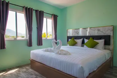two swans are sitting on a bed in a bedroom at Anatasia Apartment Phuket in Phuket Town