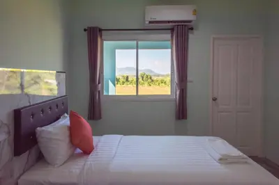 a bedroom with a bed with a window at Anatasia Apartment Phuket in Phuket Town