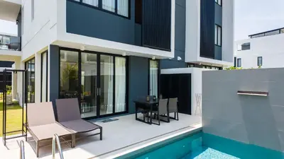 a patio with a table and chairs next to a swimming pool at Laguna Park Villa in Phuket Town
