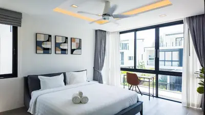 a bedroom with a bed and a large window at Laguna Park Villa in Phuket Town