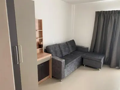 a grey couch in a room with a window at Studio Apartment in Phuket Town