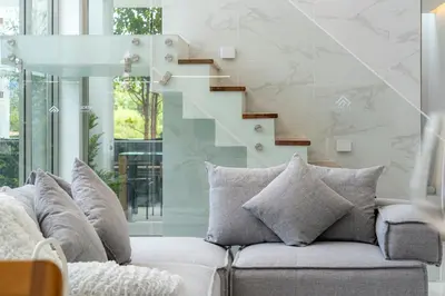 a living room with a couch and a staircase at \u90a6\u6d9b\uff08bangtao)\u82b1\u56ed\u6cf3\u6c60\u522b\u58853\u5367 in Ban Pak Lak