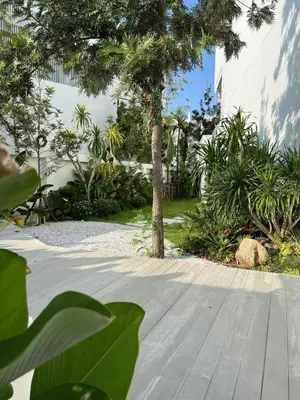a garden with a tree and a wooden walkway at \u90a6\u6d9b\uff08bangtao)\u82b1\u56ed\u6cf3\u6c60\u522b\u58853\u5367 in Ban Pak Lak