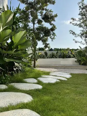 a garden with stepping stones in the grass at \u90a6\u6d9b\uff08bangtao)\u82b1\u56ed\u6cf3\u6c60\u522b\u58853\u5367 in Ban Pak Lak