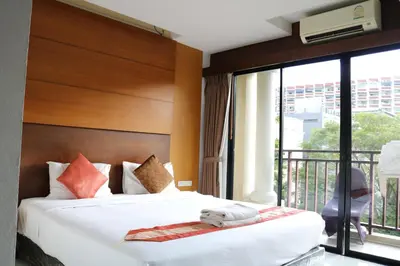 a hotel room with a bed and a balcony at Diamond Crown Hotel in Patong Beach