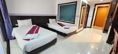 a bedroom with two beds and a large mirror at Diamond Crown Hotel in Patong Beach