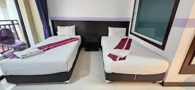 two beds sitting next to each other in a room at Diamond Crown Hotel in Patong Beach