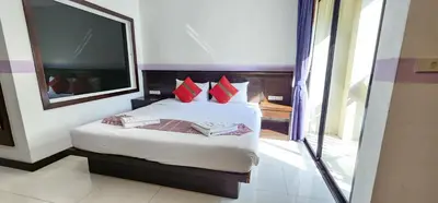 a bedroom with a bed with red pillows and a mirror at Diamond Crown Hotel in Patong Beach