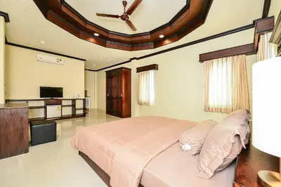a bedroom with a large bed with a ceiling fan at Group Getaway Patong House in Patong Beach