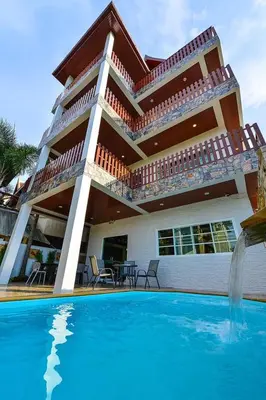 a house with a swimming pool in front of a house at Group Getaway Patong House in Patong Beach