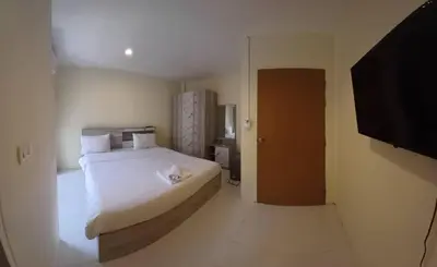 a bedroom with a bed and a flat screen tv at Lucky Seven Patong in Patong Beach