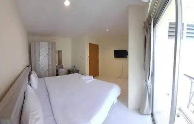 a bedroom with a white bed and a window at Lucky Seven Patong in Patong Beach