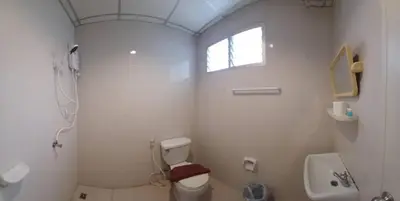 a white bathroom with a toilet and a sink at Lucky Seven Patong in Patong Beach
