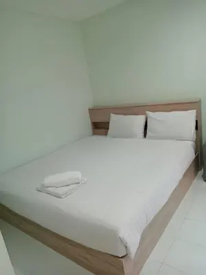 a bed with a wooden frame and white sheets and pillows at Lucky Seven Patong in Patong Beach