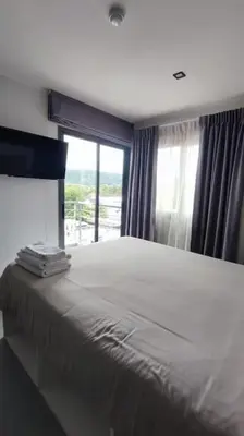 a bedroom with a large bed with a window at 1bed in Chalong