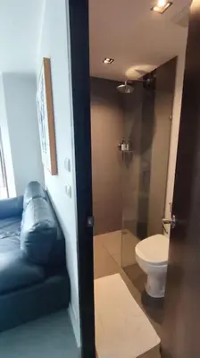 a bathroom with a toilet and a glass shower door at 1bed in Chalong