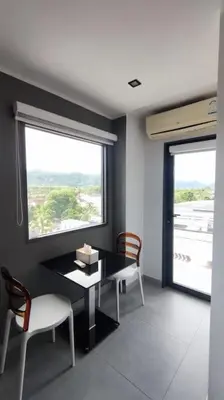 a dining room with a table and chairs and a window at 1bed in Chalong