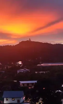 a sunset over a city with a mountain in the background at 1bed in Chalong