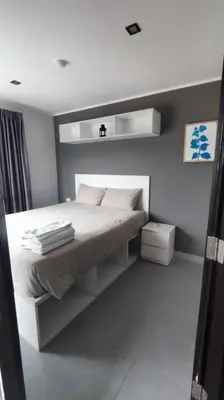 a white bedroom with a white bed with white pillows at 1bed in Chalong