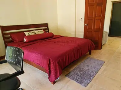 a bedroom with a bed with a red blanket and a chair at Natures relax in Kamala Beach