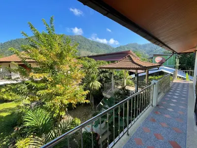 a balcony of a house with a mountain in the background at Natures relax in Kamala Beach