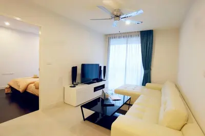 a living room with a white couch and a television at Sea view apartment at The Unity by Lofty in Patong Beach