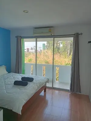 a bedroom with a bed and a large window at Bangreen Naiyang Hotel in Nai Yang Beach