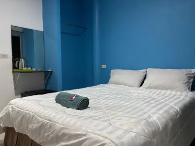a bed with a green hat on top of it at Bangreen Naiyang Hotel in Nai Yang Beach