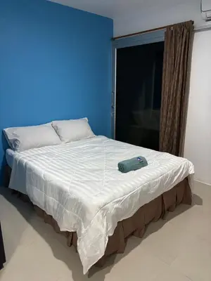 a bed in a room with a blue wall at Bangreen Naiyang Hotel in Nai Yang Beach