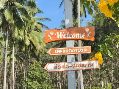 a street sign in front of some palm trees at Koh Yao unnrak Resort in Ban Lo Pla Lai (1)