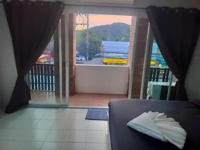 a room with a door open to a balcony with a view at the three pyramids in Phuket Town