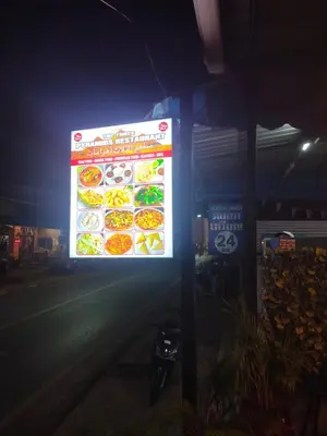 a sign for a restaurant at night at the three pyramids in Phuket Town