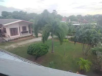 a view of a yard with palm trees and a house at the three pyramids in Phuket Town