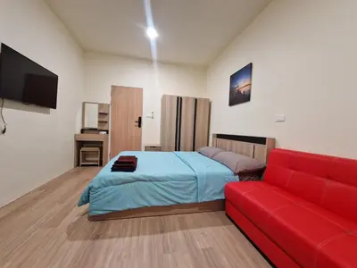 a room with a bed and a red couch at Bonanza Patong Beach1 100m to Beach Moon Room in Patong Beach