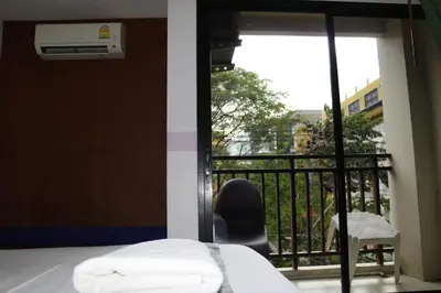 a bedroom with a balcony with a bed and a chair at Diamond Crown in Patong Beach