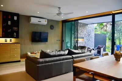 a living room with a couch and a table at Villa Papaya @ Kamala Beach in Kamala Beach