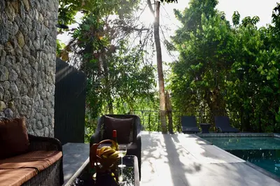a patio with a couch and a swimming pool at Villa Papaya @ Kamala Beach in Kamala Beach
