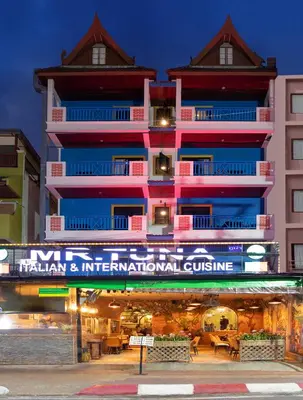 a tall building with a sign in front of it at Tuna Boutique Hotel Patong in Patong Beach