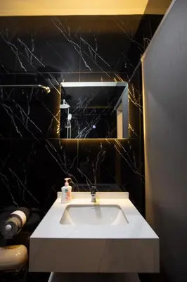 a bathroom with a white sink and a mirror at Tuna Boutique Hotel Patong in Patong Beach