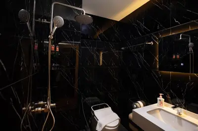 a black bathroom with a shower and a sink at Tuna Boutique Hotel Patong in Patong Beach