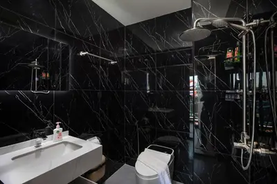 a black bathroom with a sink and a toilet at Tuna Boutique Hotel Patong in Patong Beach