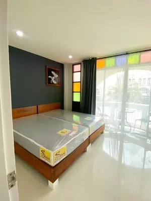 a bedroom with a bed in a room with a window at Pim's Bed and Breakfast @ Phuket in Ban Bang Khu