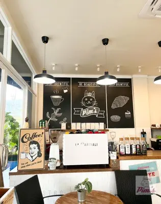 a restaurant with a counter with a chalkboard on the wall at Pim's Bed and Breakfast @ Phuket in Ban Bang Khu