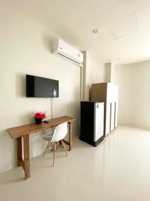 a room with a desk and a tv and a refrigerator at Pim's Bed and Breakfast @ Phuket in Ban Bang Khu