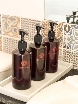 three bottles of soap on a shelf in a bathroom at Pim's Bed and Breakfast @ Phuket in Ban Bang Khu