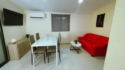 a living room with a red couch and a table at Blackberry in Rawai Beach