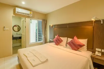 a bedroom with a large white bed with red pillows at Khao Rang Place in Phuket Town