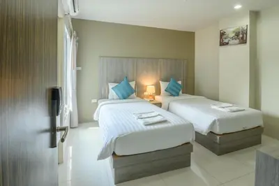a bedroom with two beds and a lamp at Khao Rang Place in Phuket Town