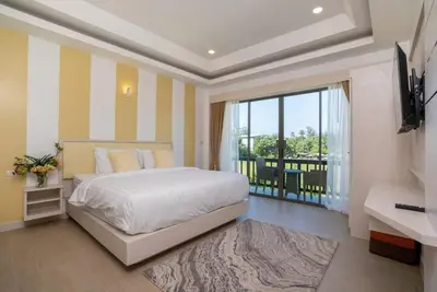 a bedroom with a bed and a television and a balcony at Pure Bliss Luxe 3BR Pool Villa Your Ultimate Tropical Getaway V29 V74 in Bang Tao Beach